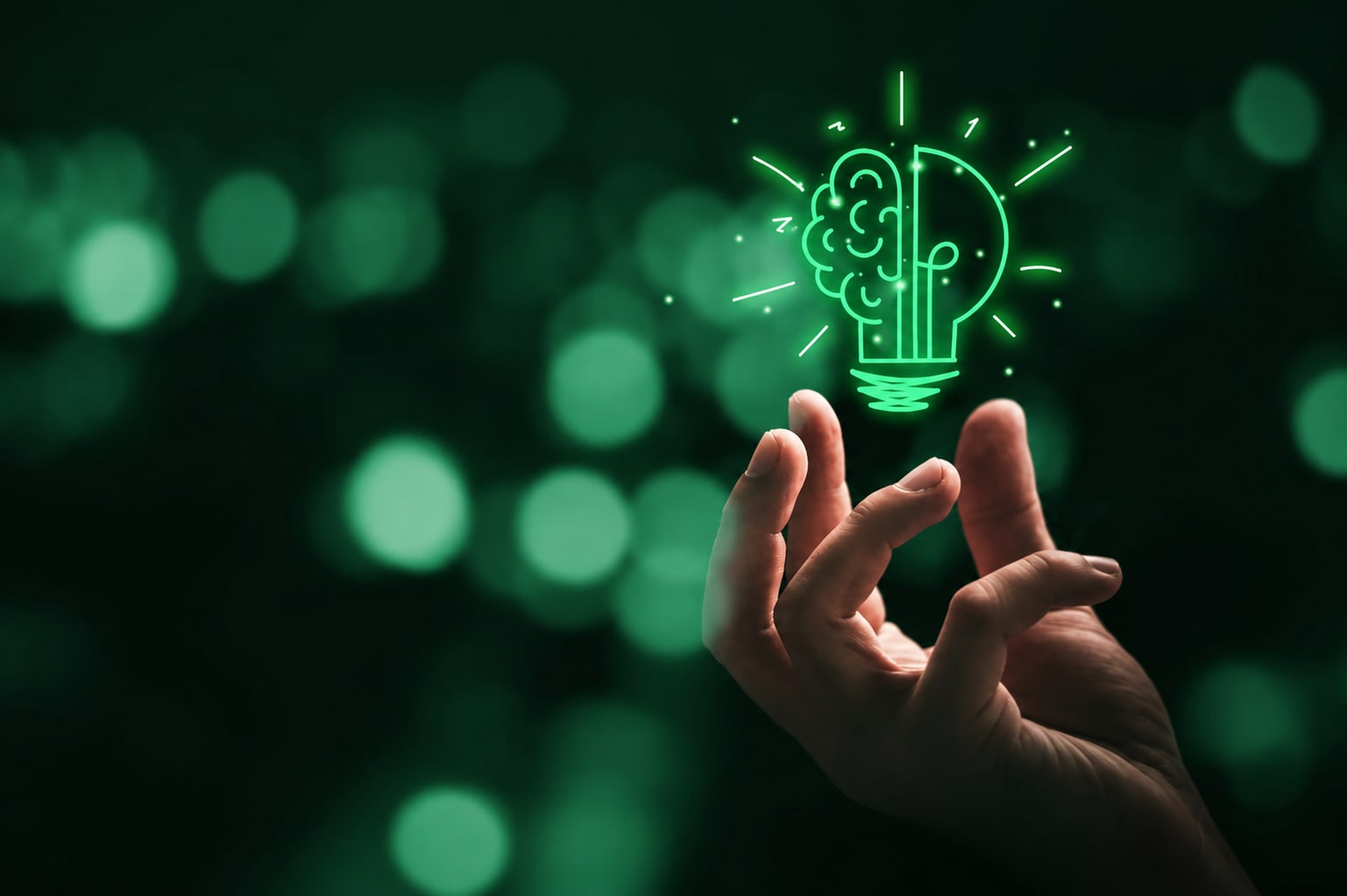 Main tendue sous une ampoule lumineuse verte, symbole du lancement d'un projet